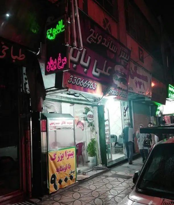 نمای شب از پیتزا ساندویچ علی بابا، فست فودی جذاب با انواع پیتزا، ساندویچ و مرغ بریان. پیشنهاد ویژه: پیتزا بزرگ با نوشابه.