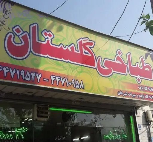 تصویری از تابلوی مغازه طباخی گلستان، متخصص کله پاچه و سیراب شیردان، همراه با شماره تماس ۴۴۷۱۹۵۳۷ و ۴۴۷۱۰۹۵۸.