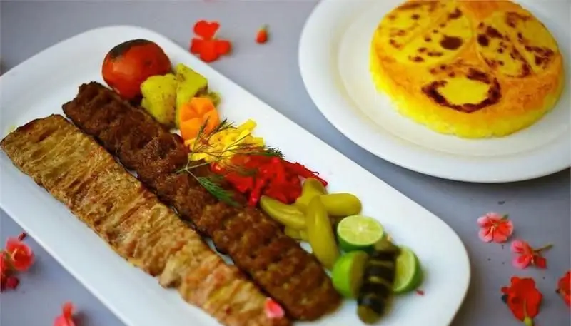 کباب کوبیده و جوجه با ته دیگ زعفرانی، گوجه کبابی، ترشیجات، لیمو و مخلفات در کافی شاپ موروکو، غذای خوشمزه.