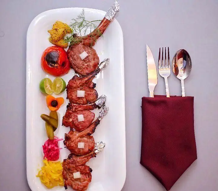 نمایی اشتهاآور از دنده کباب‌های رستورانی کافی شاپ موروکو، همراه با مخلفات متنوع از جمله گوجه کبابی، لیمو و انواع ترشی. تجربه‌ای خوشمزه و کامل.