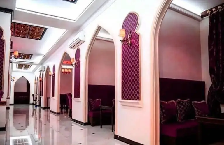 دکوراسیون داخلی لوکس کافی شاپ موروکو با طاق‌های سنتی، مبلمان بنفش شیک و نورپردازی گرم، فضایی آرامش‌بخش برای مشتریان.