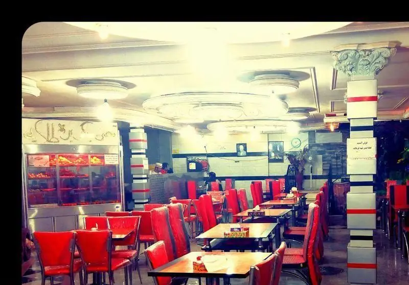 فضای داخلی دنج و دلنشین رستوران قصر جگر بره طلایی با میز و صندلی‌های قرمز، آماده پذیرایی از مشتریان برای سرو جگر و غذای لذیذ.
