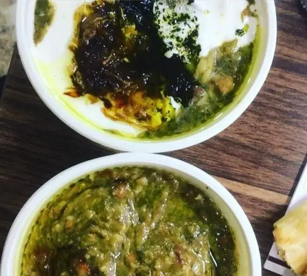 تصویری دلپذیر از آش‌های سنتی و خوشمزه آش نیکوصفت. دو کاسه آش ایرانی با تزئینات متنوع، آماده سرو در آش و حلیم پزی نیکوصفت.