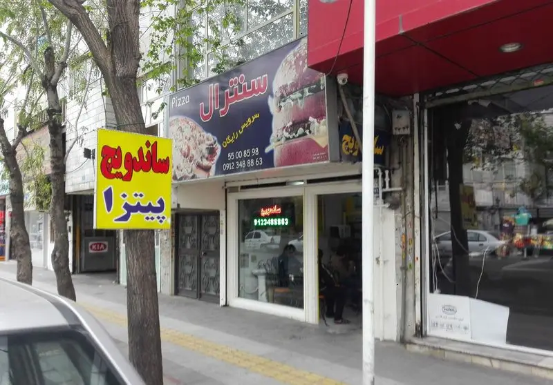 تصویری از نمای بیرونی پیتزا سنترال، فست فود ارائه دهنده پیتزا و ساندویچ با شماره تلفن ها و سرویس تحویل رایگان.