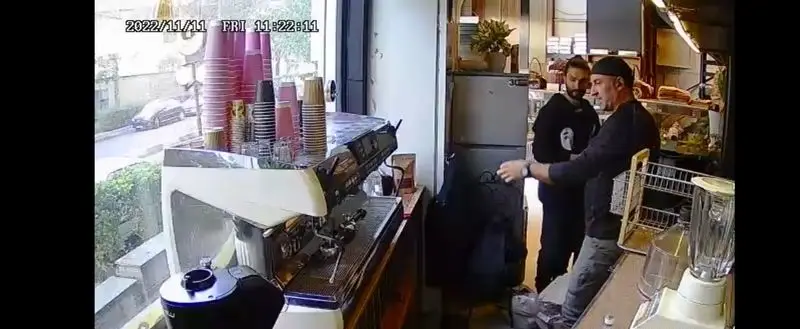 تصویری از کافه آ، با دستگاه اسپرسوساز حرفه ای، فنجان های قهوه و کارکنان در حال آماده سازی. فضای گرم و دلنشین برای مشتریان.