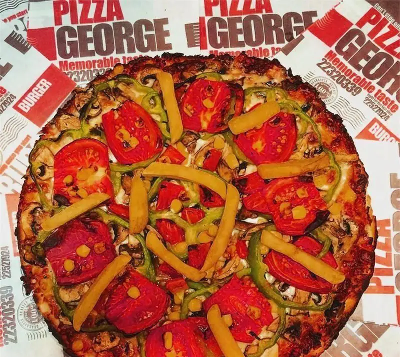 پیتزا ژرژ تازه و خوشمزه با مخلفات متنوع شامل سیب زمینی سرخ کرده، گوجه فرنگی، فلفل دلمه ای سبز، قارچ و ذرت. طعم به یاد ماندنی از ژرژ.