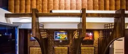 فضای داخلی دکوراتیو فست فود شاپرک با دیوارهای آجری، تیرهای چوبی و تزئینات سقفی، نشان‌دهنده محیطی گرم و دلنشین.