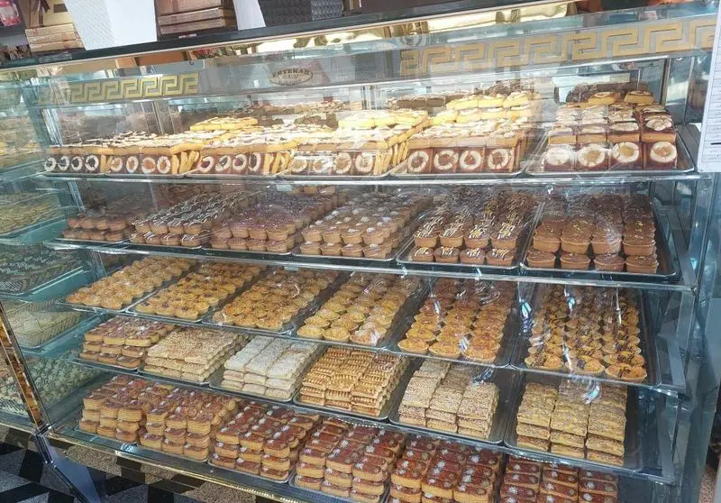 ویترین پربار شیرینی فروشی باران با چیدمان زیبای انواع شیرینی‌های سنتی و مدرن، کلوچه، باقلوا و دسر. طعمی به یادماندنی.
