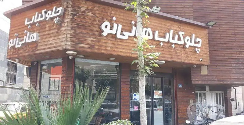 نمای بیرونی رستوران چلوکباب هانی نو با تابلوی چوبی زیبا و ورودی شیشه‌ای، مکانی برای لذت بردن از چلوکباب‌های اصیل ایرانی در تهران.