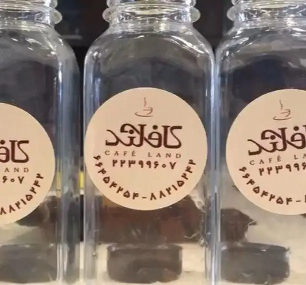 سه بطری شیشه‌ای شفاف برند کافه‌لند با برچسب لوگوی فنجان قهوه و نام Cafe Land. شماره تماس ۲۲۳۹۹۶۰۷ برای سفارش نوشیدنی.