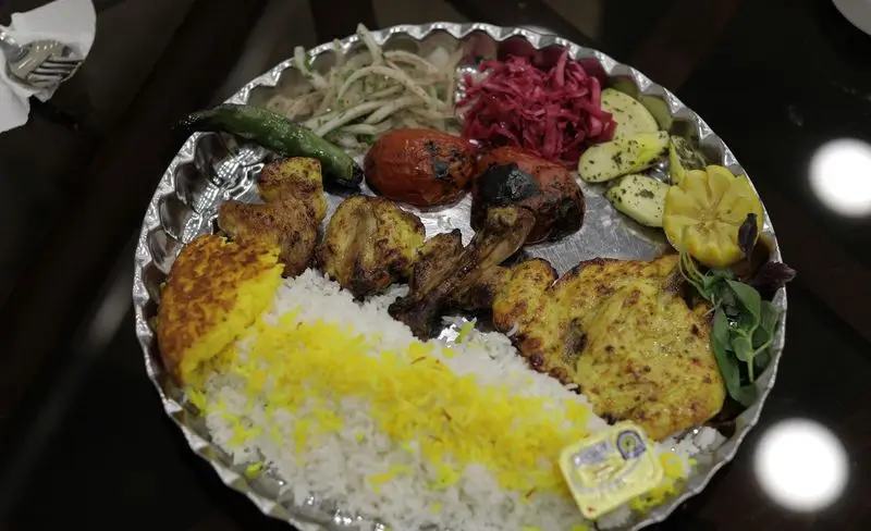 بشقاب شاهانه چلو کباب جوجه و کباب استخوان‌دار با برنج زعفرانی، گوجه، فلفل، لیمو و مخلفات در رستوران سنتی شهر آفتاب.