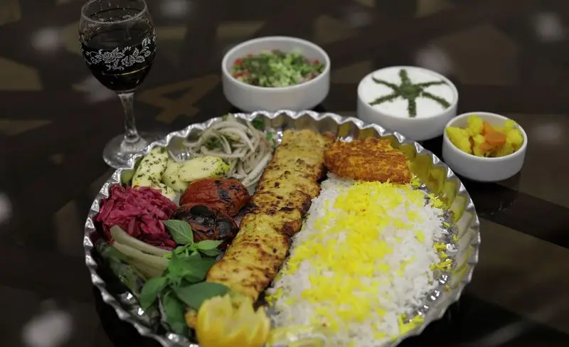غذای سنتی ایرانی رستوران شهر آفتاب: چلو جوجه کباب با برنج زعفرانی، گوجه کبابی، سبزی خوردن، سالاد، ماست و خیار و ترشی. لذت یک وعده کامل.