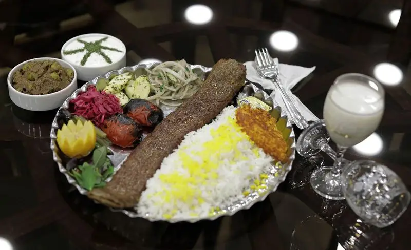 کباب کوبیده با برنج زعفرانی، ته دیگ، گوجه کبابی و ماست از رستوران سنتی شهر آفتاب. یک غذای اصیل و خوشمزه ایرانی.
