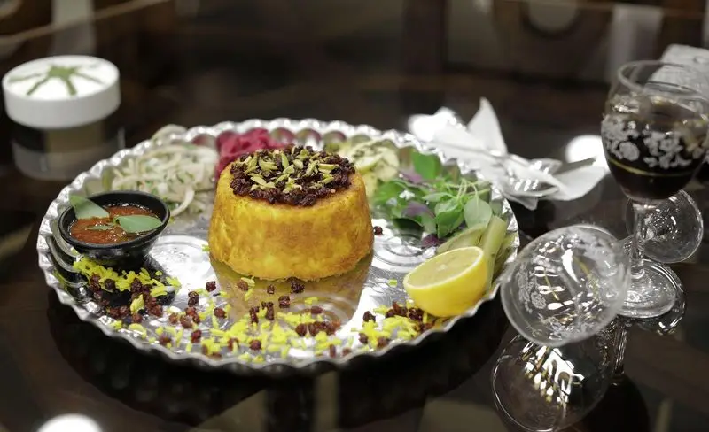 رستوران سنتی شهر آفتاب: ته‌چین زرشک و خلال پسته با سینی مسی، سبزی، سس و لیمو، تجربه‌ای از غذای اصیل و دلپذیر ایرانی.