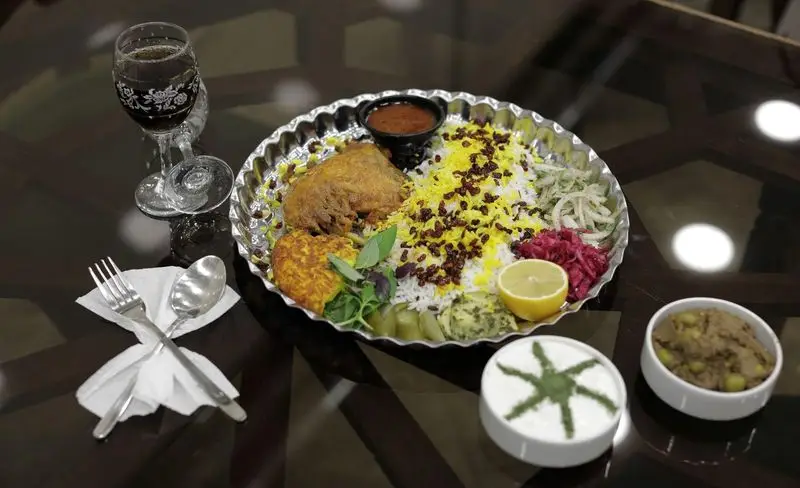 سفره مجلل رستوران سنتی شهر آفتاب با زرشک پلو مرغ، کوکو، ماست، ترشی و نوشیدنی. تجربه‌ای اصیل از غذای ایرانی.