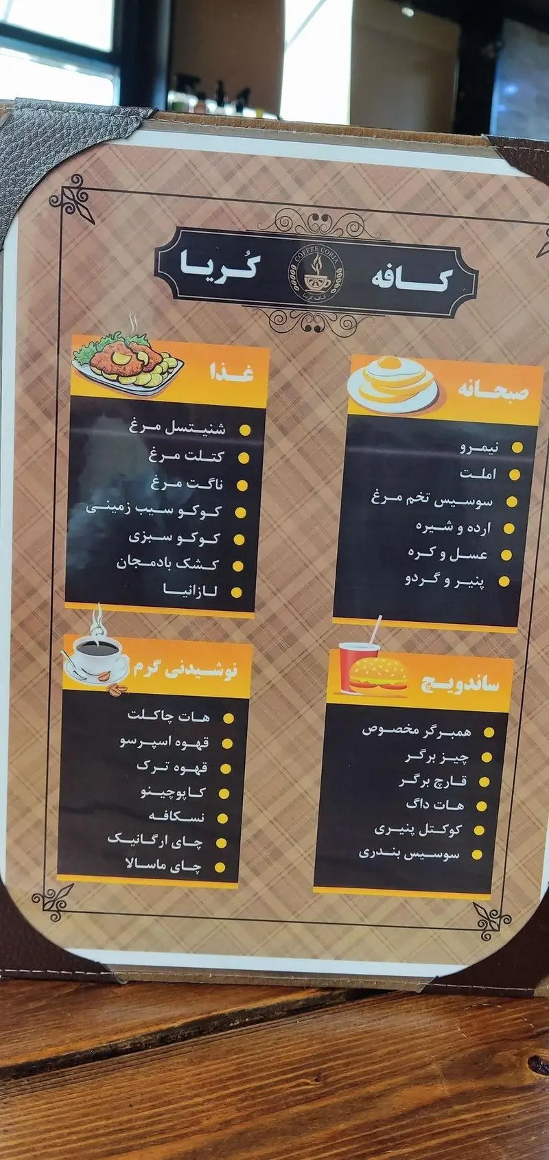 منو کافه کُریا: انواع غذاها (شنیتسل، ناگت)، صبحانه (نیمرو، املت)، نوشیدنی‌های گرم (قهوه، هات چاکلت) و ساندویچ (همبرگر، هات داگ).