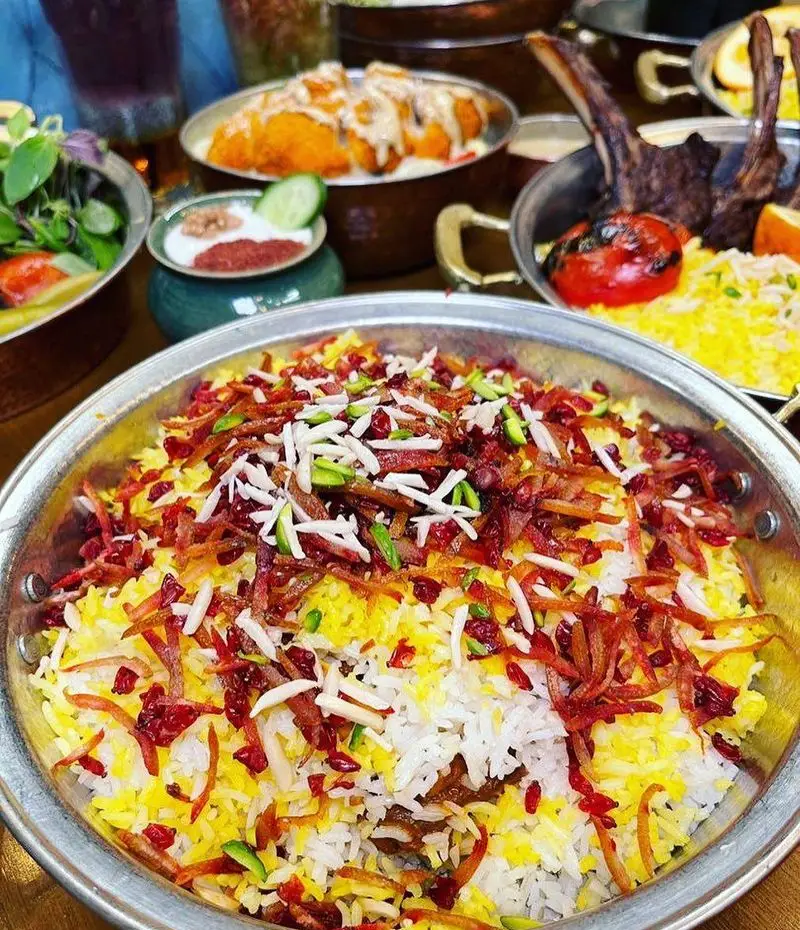 سفره‌ای شاهانه از رستوران پیاله: زرشک پلو مجلسی با خلال پسته و بادام، شیشلیک، برنج زعفرانی، چیکن و پیش غذاهای ایرانی.