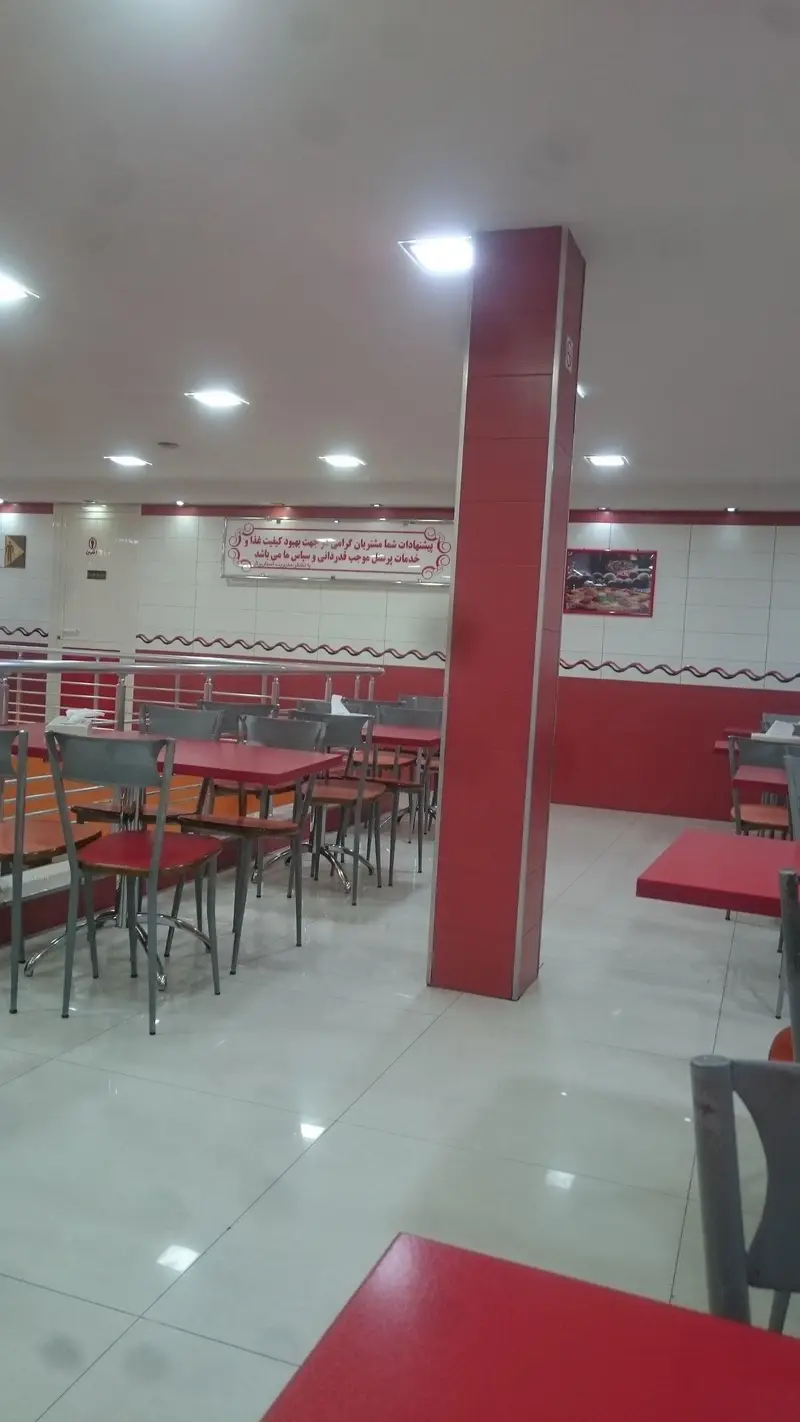 نمایی از سالن غذاخوری رستوران فست فود استار برگر با دکوراسیون قرمز و سفید، شامل میزهای قرمز و صندلی‌های شیک، فضایی دلنشین برای صرف غذا.