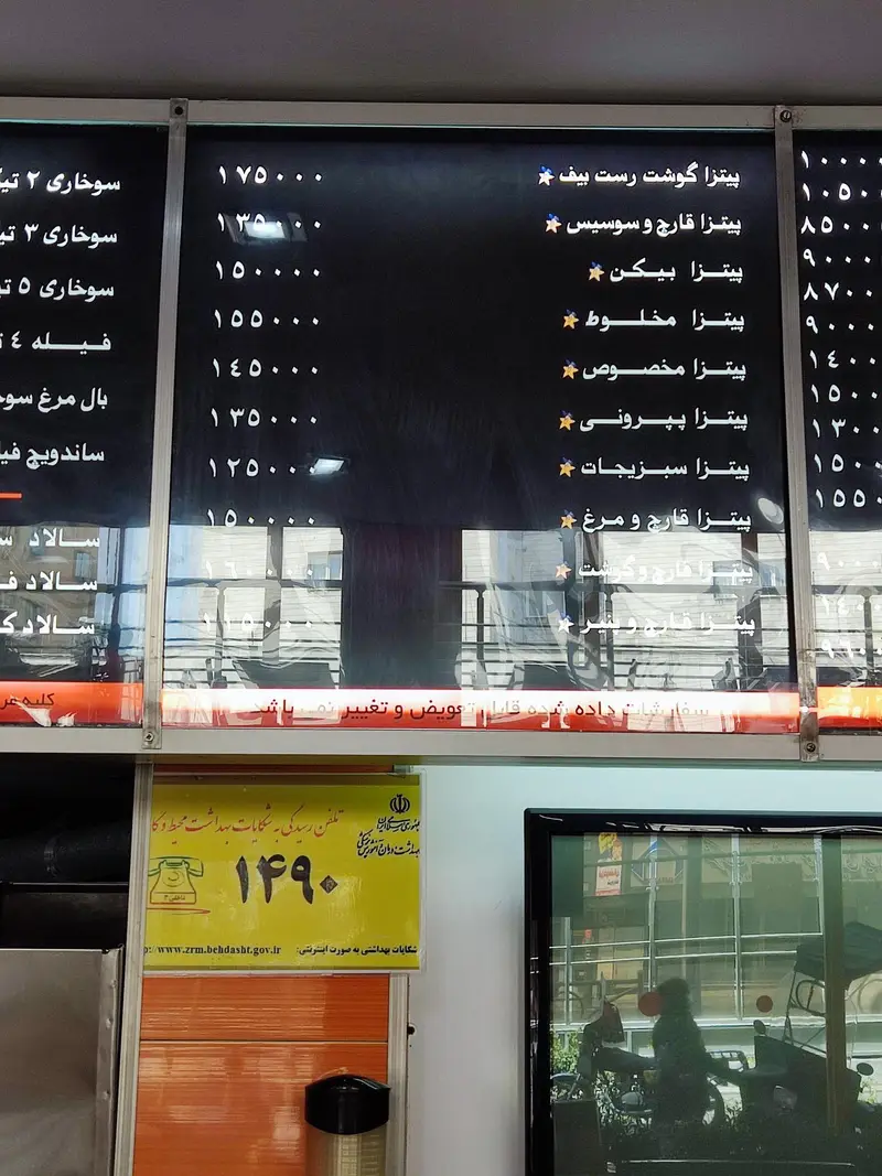 منوی رستوران استار برگر شامل انواع پیتزا (رست بیف، قارچ و سوسیس، پپرونی، سبزیجات) و قیمت‌های به‌روز. تابلو راهنمای بهداشت نیز دیده می‌شود.