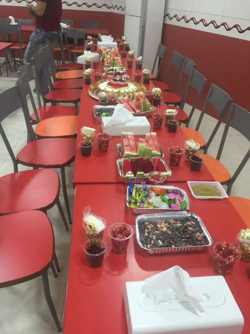 میز جشن یلدایی در استار برگر، با هندوانه، انار، آجیل و دسرها. فضایی گرم و دوستانه برای دورهمی و خاطره سازی در رستوران.