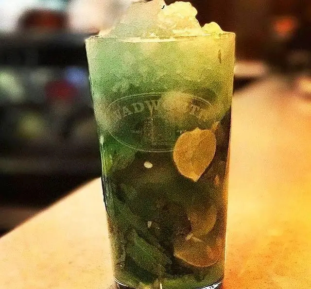 لیوان بلند موهیتو خنک و گوارا با یخ خرد شده، نعنای تازه و برش‌های لیمو. انتخابی دلپذیر در کافی شاپ تی شن.