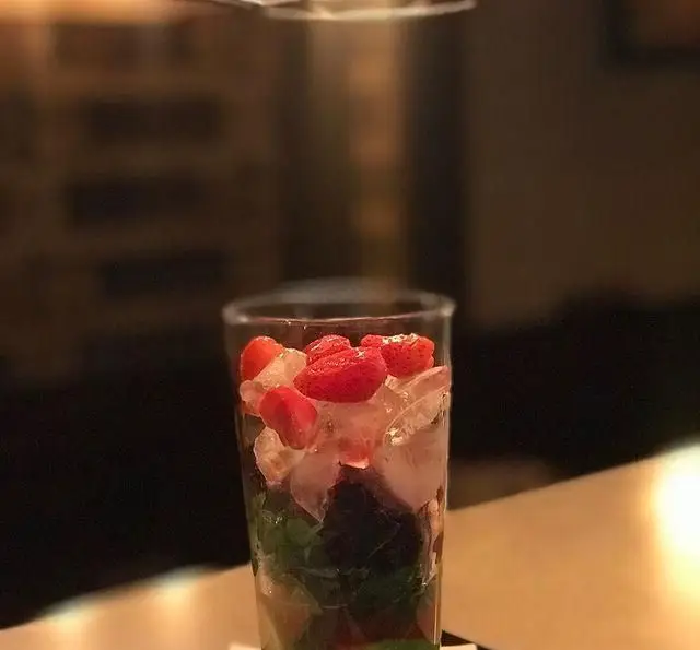 تصویری جذاب از نوشیدنی موهیتو توت فرنگی و نعناع با یخ در لیوانی بلند، پیشنهادی خنک از کافی شاپ تی شن برای روزهای تابستانی.