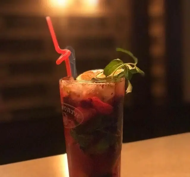 کوکتل میوه‌ای خنک و گوارا با تکه‌های توت‌فرنگی، برگ نعنا و لیمو خشک در لیوان کافی شاپ تی شن برای لذت‌بخش‌ترین لحظات.