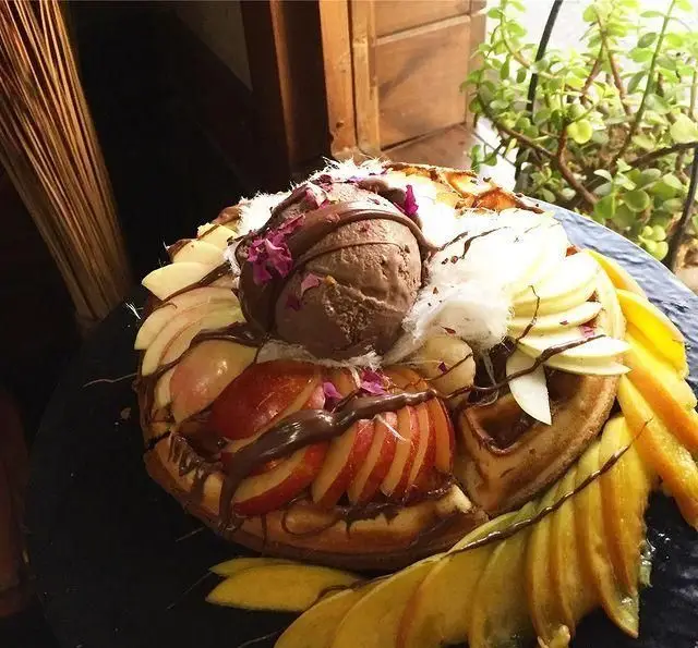 وافل لوکس و دلنشین کافی شاپ تی شن با بستنی شکلاتی، تکه های سیب و انبه تازه، سس غلیظ شکلات و پشمک برای یک تجربه شیرین در تهران.