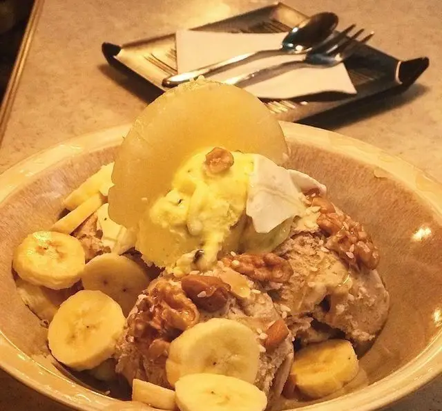 دسر میوه‌ای و خوشرنگ کافی شاپ تی شن با بستنی، موز، گردو و برش آناناس، انتخابی ایده‌آل برای روزهای گرم.