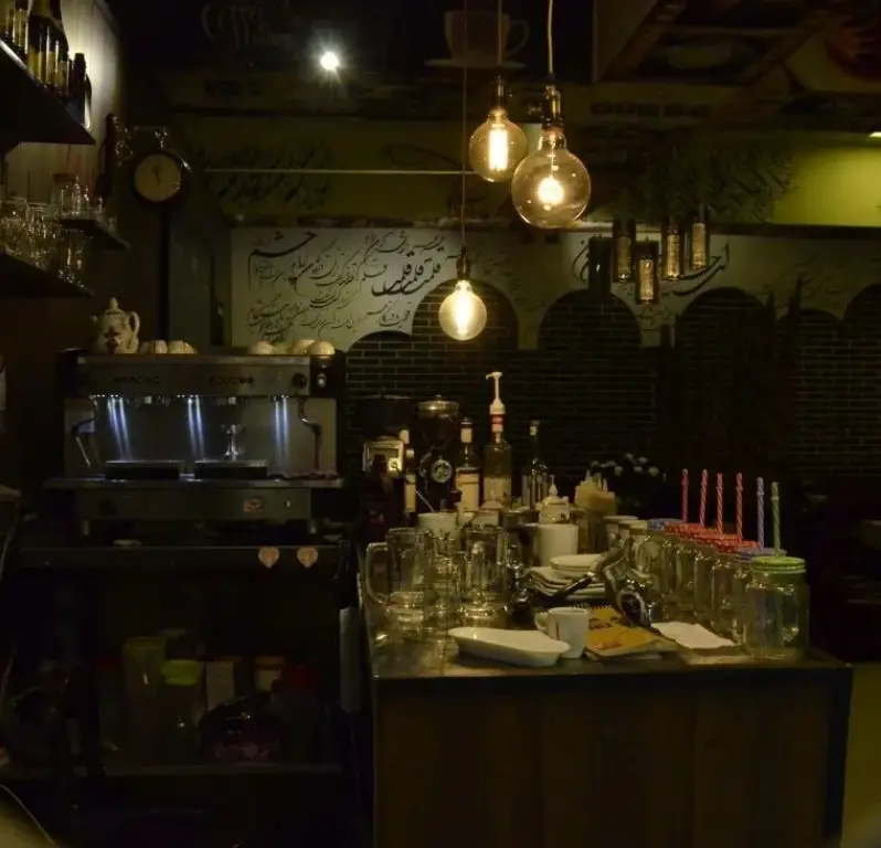 فضای داخلی کافه جاپا، شامل پیشخوان مجهز، دستگاه اسپرسوساز، آسیاب قهوه، لیوان‌های تمیز و نورپردازی جذاب لامپ‌های ادیسونی.