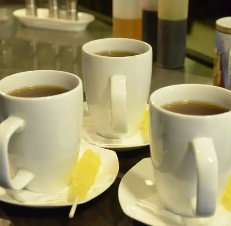 سه فنجان چای داغ در کافه جاپا، همراه با نبات‌های زرد خوشرنگ، لحظاتی دلپذیر برای مشتریان. محیطی گرم و دلنشین.