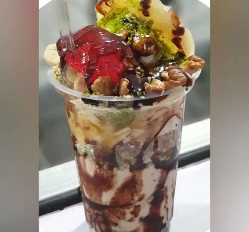 میکس میوه و بستنی آبمیوه شهریور، دسری خاص با لایه‌های بستنی، سس شکلات و میوه، مغز گردو و پسته روی آن