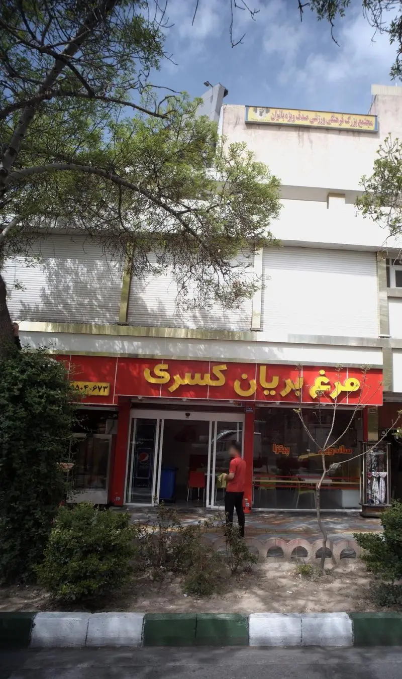 نمای بیرونی مرغ بریان کسری، رستوران فست فود و غذای آماده. شامل تابلوی فروشگاه، ورودی و پیاده‌رو. مجتمع صدف نیز در پس‌زمینه دیده می‌شود.
