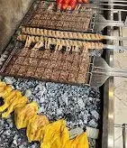 آماده‌سازی لذیذترین انواع کباب ذغالی شامل دنده کباب، کباب کوبیده و جوجه کباب تازه در رستوران دنده کباب طاق بستان.