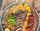 سینی مجلل کباب میکس دنده کباب طاق بستان شامل انواع کباب: دنده، جوجه، کوبیده، برگ، ماهی و سبزیجات تازه در رستوران.