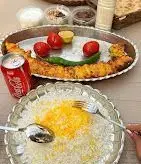 تصویر دنده کباب اصیل کرمانشاهی سرو شده با برنج زعفرانی، گوجه کبابی و مخلفات در رستوران دنده کباب طاق بستان.