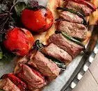 کباب دنده گوسفندی اصیل کرمانشاهی، آبدار و لذیذ همراه با گوجه کبابی در رستوران دنده کباب طاق بستان.