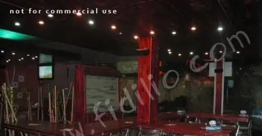 فضای داخلی مدرن و جذاب فست فود باگت با میز و صندلی‌های قرمز رنگ و نورپردازی گرم، محیطی ایده‌آل برای صرف غذا.