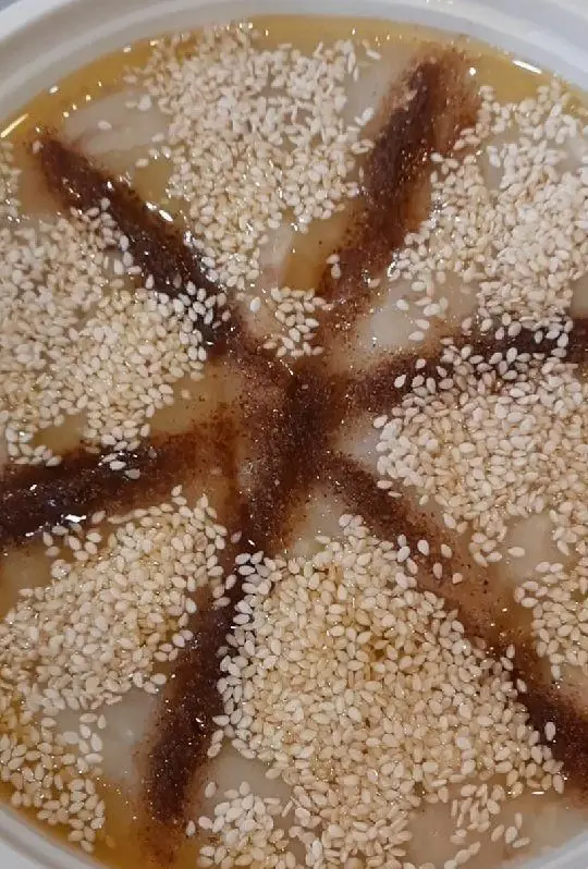 دسر یلدایی خاص غذا کده یلدا خانوم، با رویه‌ای از کنجد سفید و نقش‌ونگار سس قهوه‌ای، طعمی بی‌نظیر و ظاهری دلنشین.