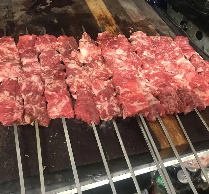 سیخ‌های پر از گوشت قرمز تازه و مرغوب، آماده برای کباب شدن و لذت بردن از طعم بی‌نظیر در جگرسرای نیلوفر. تجربه‌ای ماندگار.