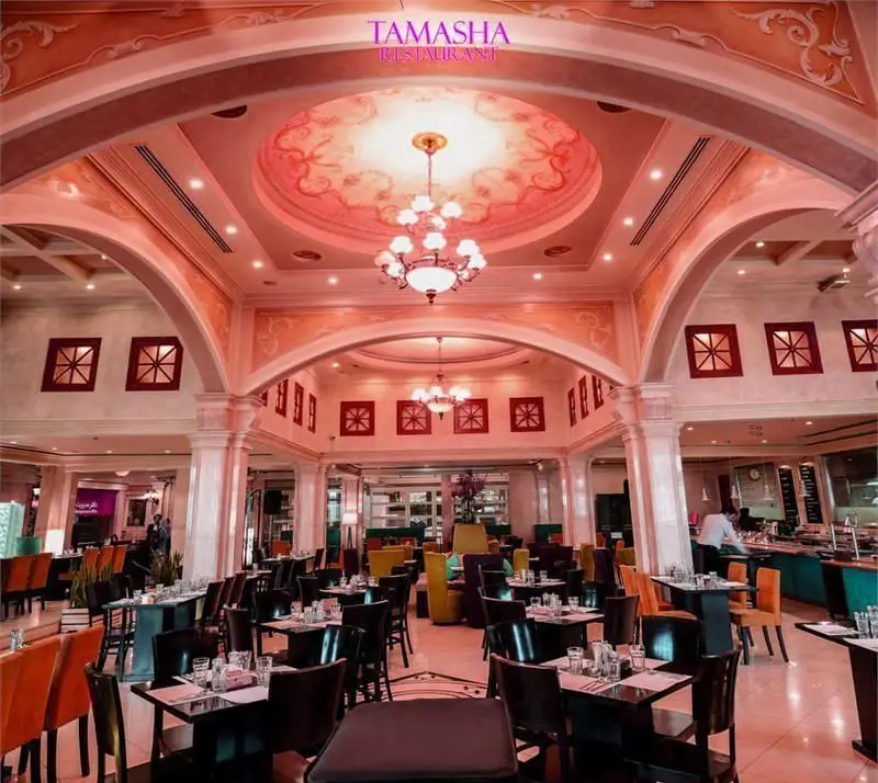 تصویر دکوراسیون داخلی شیک و لوکس رستوران تماشا با سالن غذاخوری بزرگ، سقف گنبدی تزئین شده و نورپردازی دلنشین.