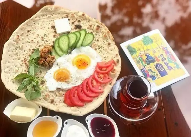 کافی شاپ ایرو: صبحانه دلپذیر و سنتی ایرانی شامل نیمرو، نان تازه، پنیر، کره، عسل، مربا، سبزی، گوجه، خیار و چای.