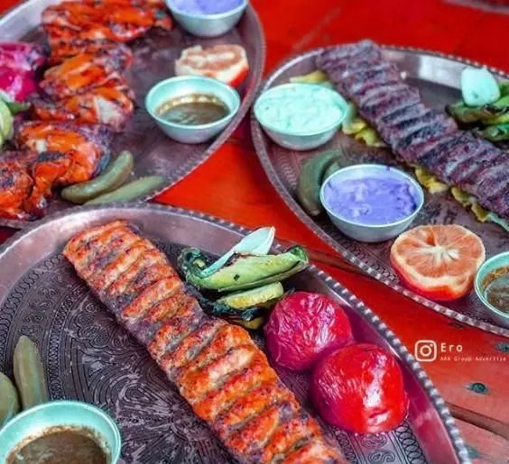 سینی‌های کباب جوجه، کباب کوبیده و غذاهای سنتی خوشمزه ایرانی در کافی شاپ ایرو با مخلفات متنوع و رنگارنگ و سس‌های خاص.
