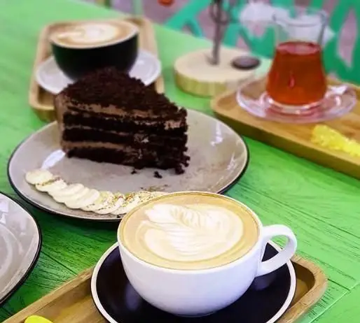 کیک شکلاتی و قهوه لاته با لاته آرت زیبا در کافی شاپ ایرو؛ تجربه طعم های دلنشین در فضایی آرامش بخش با انواع نوشیدنی و دسر.