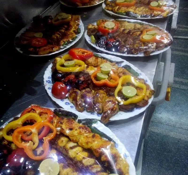 رستوران پاسارگاد: سینی‌های اشتهاآور کباب، جوجه، ماهی کبابی و دیگر غذاهای گریل شده، با فلفل دلمه، لیمو و گوجه. غذای ایرانی.