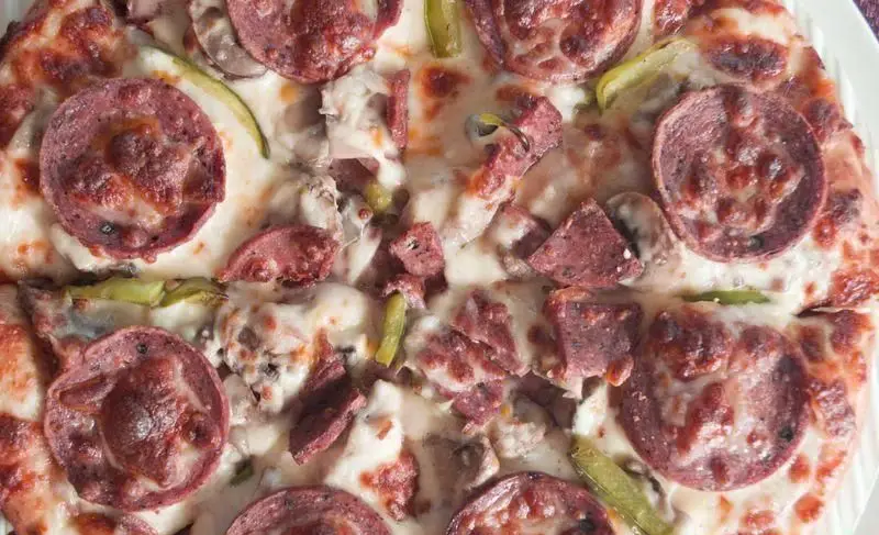 پیتزا پرطرفدار وتوس با تکه‌های کالباس، قارچ و فلفل سبز، غرق در پنیر کشدار و طلایی، ایده‌آل برای یک تجربه طعم لذیذ و بی‌نظیر.