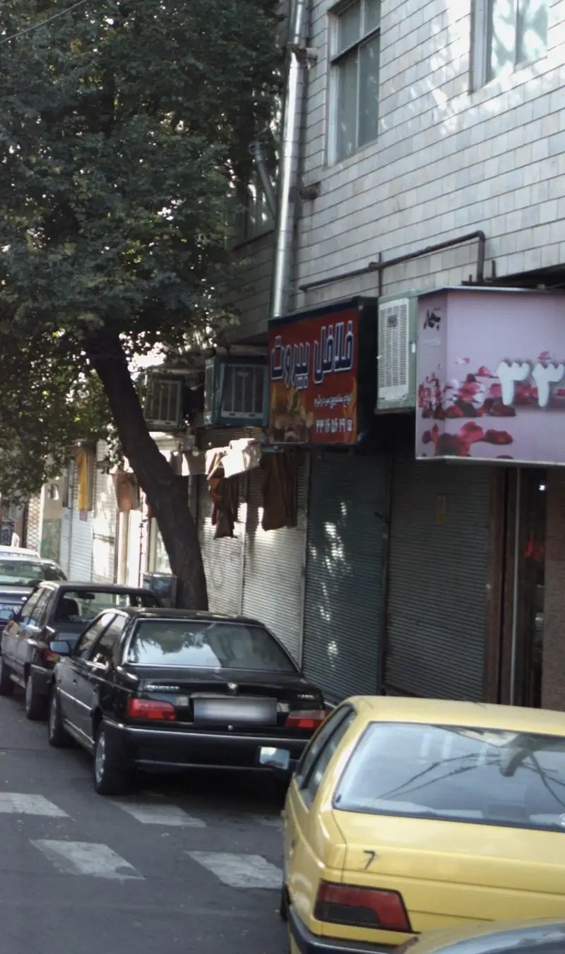 فلافل بیروت، اغذیه‌ای محبوب برای ساندویچ فلافل‌های اصیل و خوش‌طعم، در دل خیابان شهری با اتومبیل‌های پارک شده و درختان سرسبز.