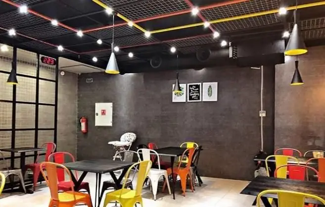 محیط داخلی دلنشین و مدرن رستوران ایتالیایی آرت گریل؛ دکوراسیون شیک، صندلی‌های رنگارنگ و نورپردازی جذاب برای مهمانان.