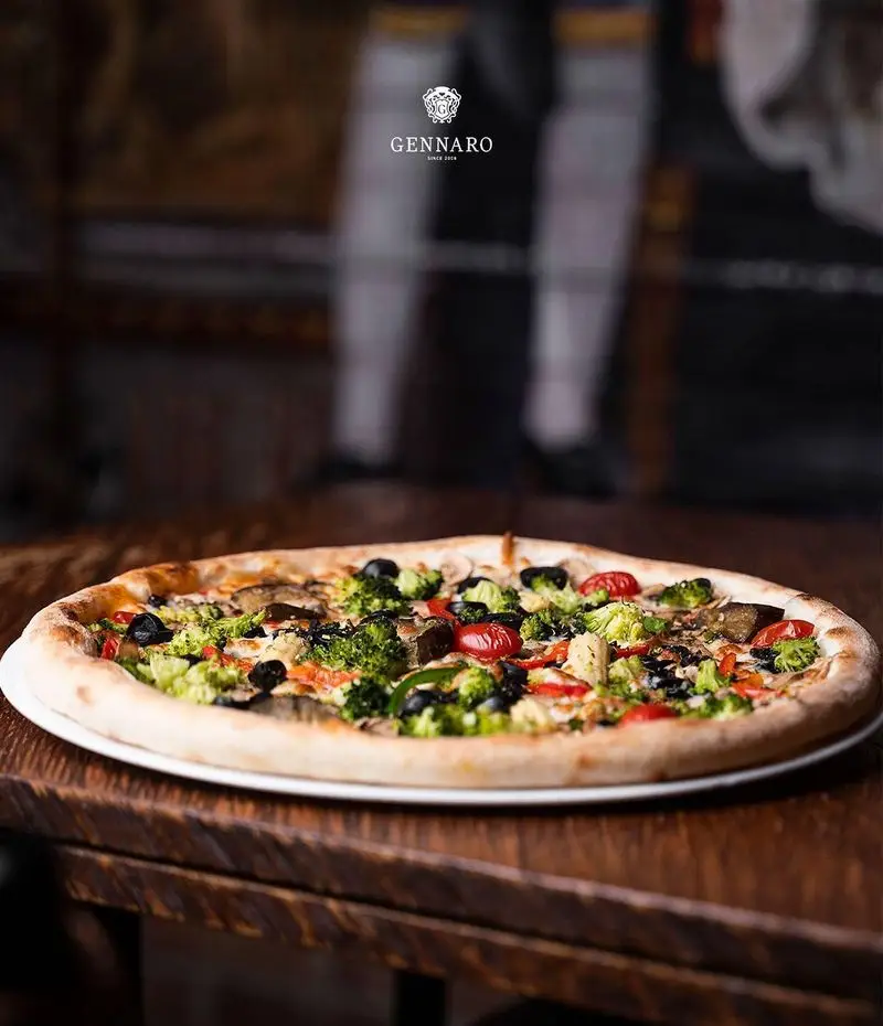 نمای نزدیک از پیتزا سبزیجات اشتهاآور و لذیذ رستوران ایتالیایی جنارو، مناسب برای تجربه یک غذای سالم و خوش طعم.