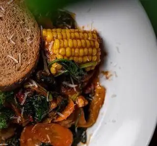 غذای گیاهی و سالم رستوران ایتالیایی جنارو، شامل ذرت، سبزیجات تازه، گوجه‌فرنگی و نان تست قهوه‌ای. طعم اصیل ایتالیایی.